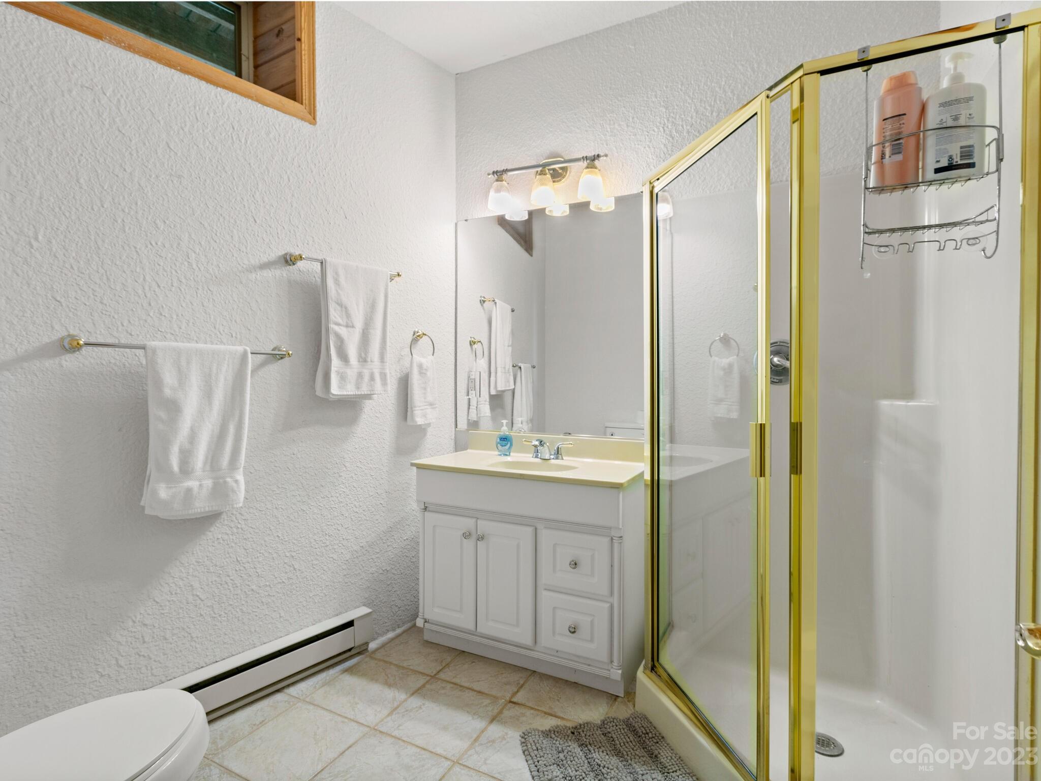 39 Rising Sun Road Candler, NC 28715 - Photo 32 of 41 a bathroom with a granite countertop sink a mirror and a shower