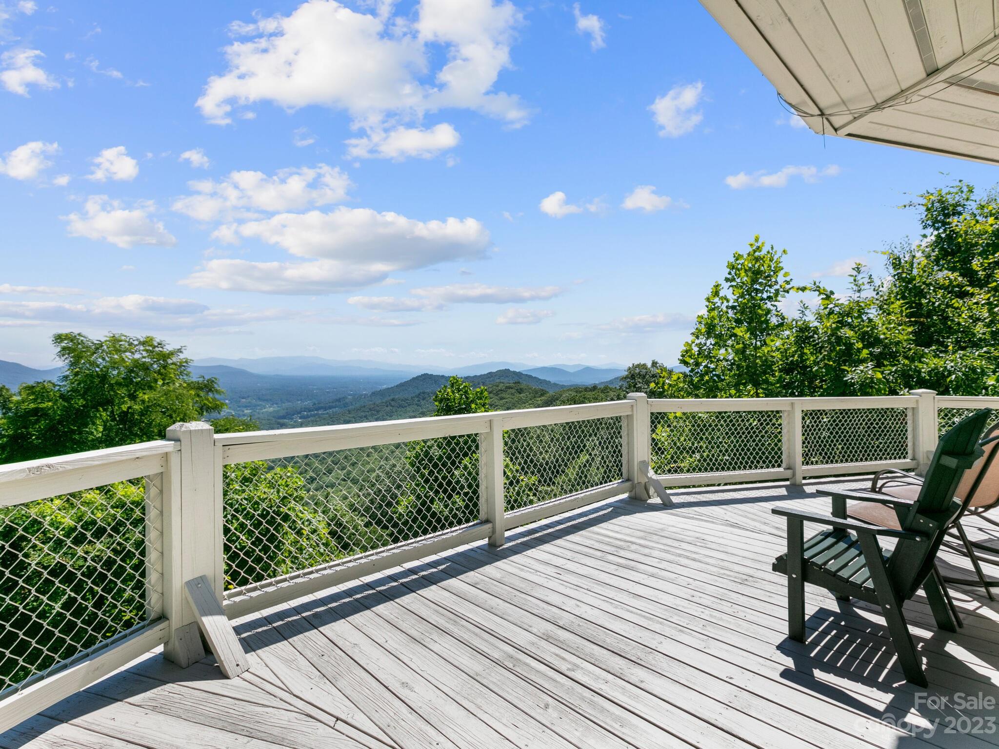 39 Rising Sun Road Candler, NC 28715 - Photo 8 of 41 a view of a chairs and table on the wooden deck