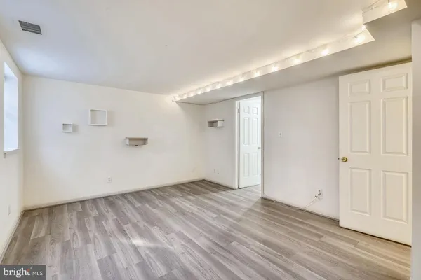 a view of an empty room with wooden floor