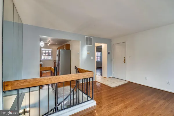 a view of a hallway with wooden floor and staircase