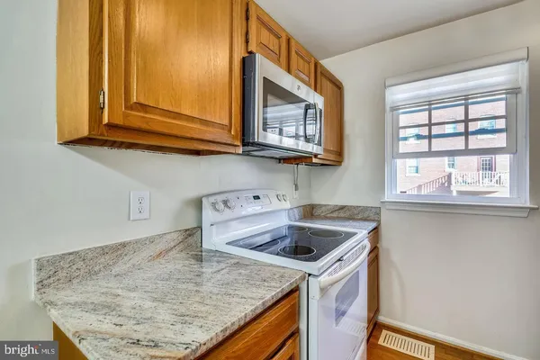a kitchen with stainless steel appliances granite countertop a sink and a microwave