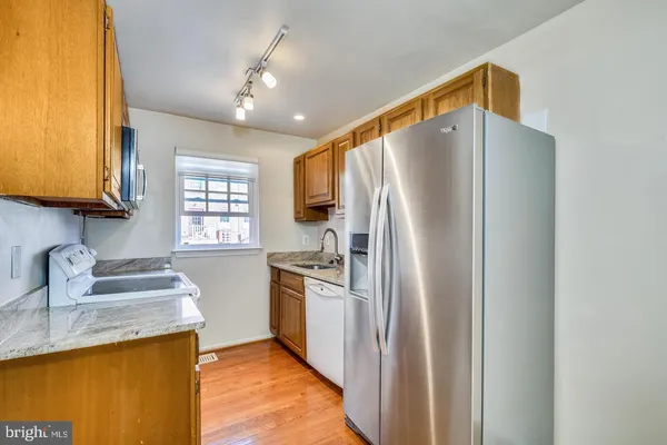 a kitchen with stainless steel appliances granite countertop a refrigerator and a sink