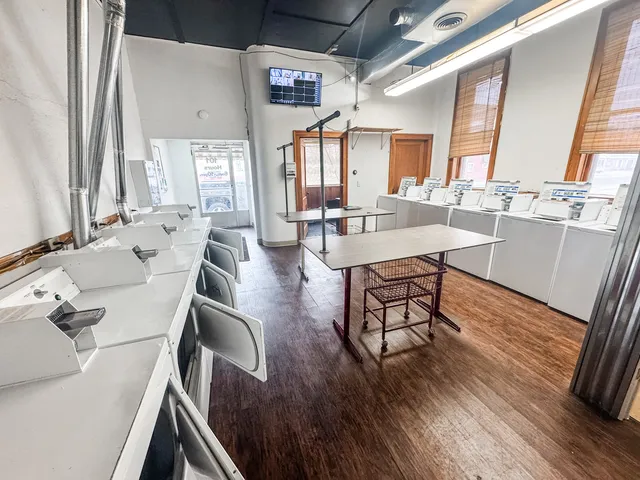 a large kitchen with a table chairs wooden floor and a window