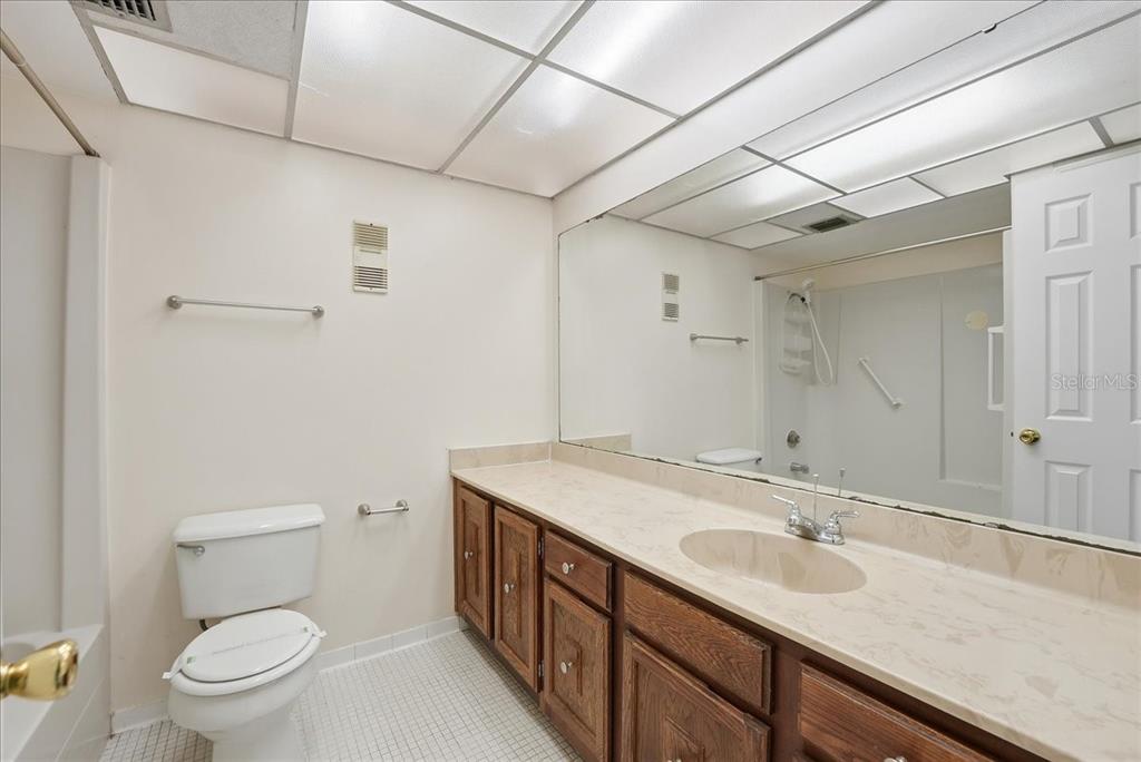 1428 Oak Place, Unit C Apopka, FL 32712 - Photo 9 of 16 a bathroom with a sink a toilet a mirror and vanity