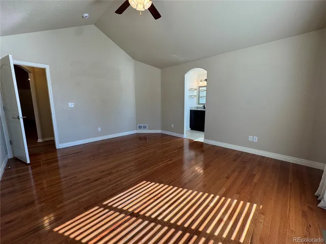 a view of a livingroom with wooden floor and staircase