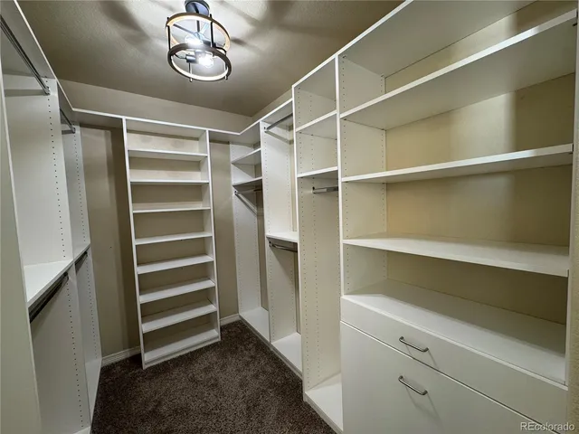 a view of walk in closet with empty racks