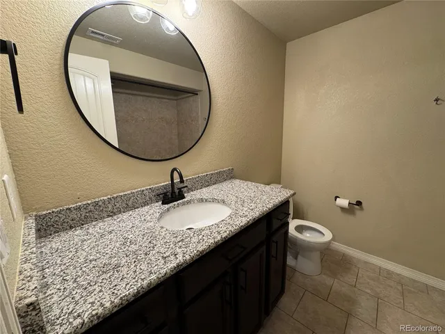a bathroom with a granite countertop sink and a mirror