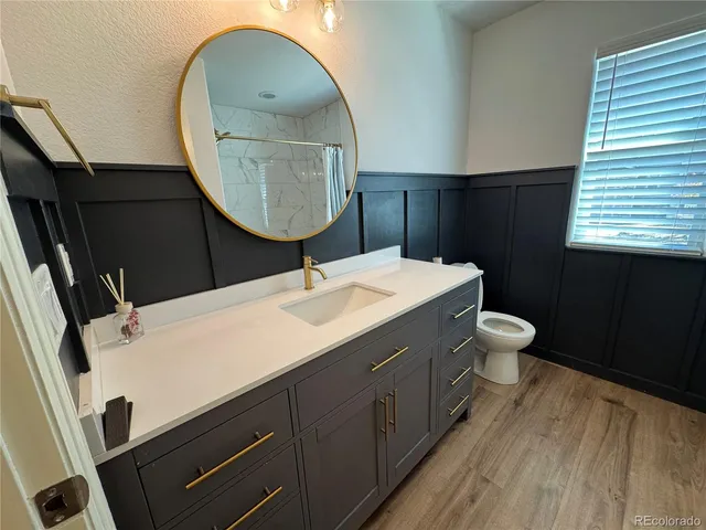 a bathroom with a sink mirror vanity and toilet