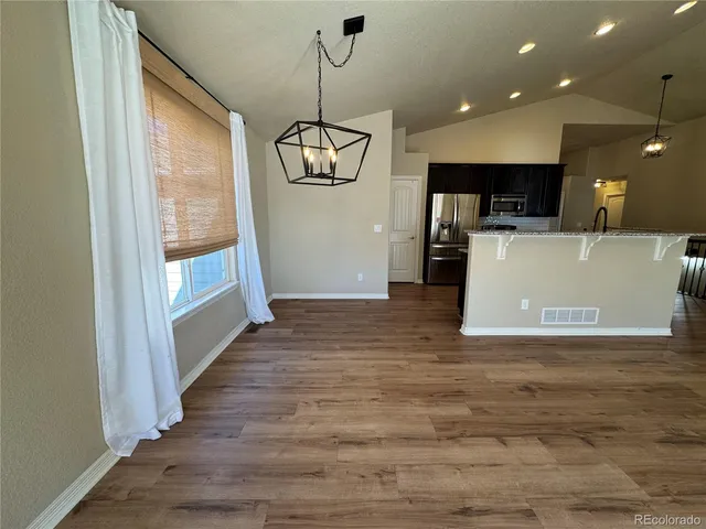a view of a living room and kitchen with furniture wooden floor and windows