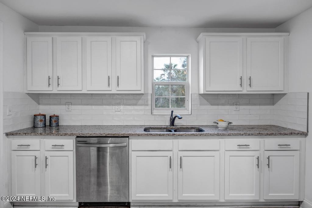 4623 Ribault Park Street Jacksonville, FL 32233 - Photo 14 of 30 a kitchen with granite countertop white cabinets and white appliances