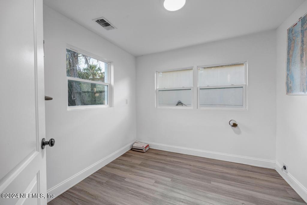 4623 Ribault Park Street Jacksonville, FL 32233 - Photo 26 of 30 an empty room with wooden floor and windows