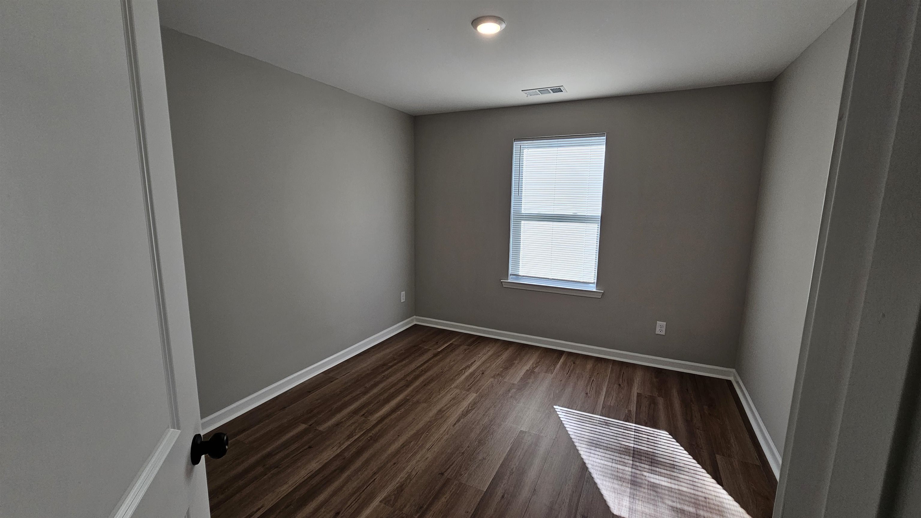 2234 East Alcy Road Memphis, TN 38114 - Photo 11 of 23 a view of an empty room with wooden floor and a window