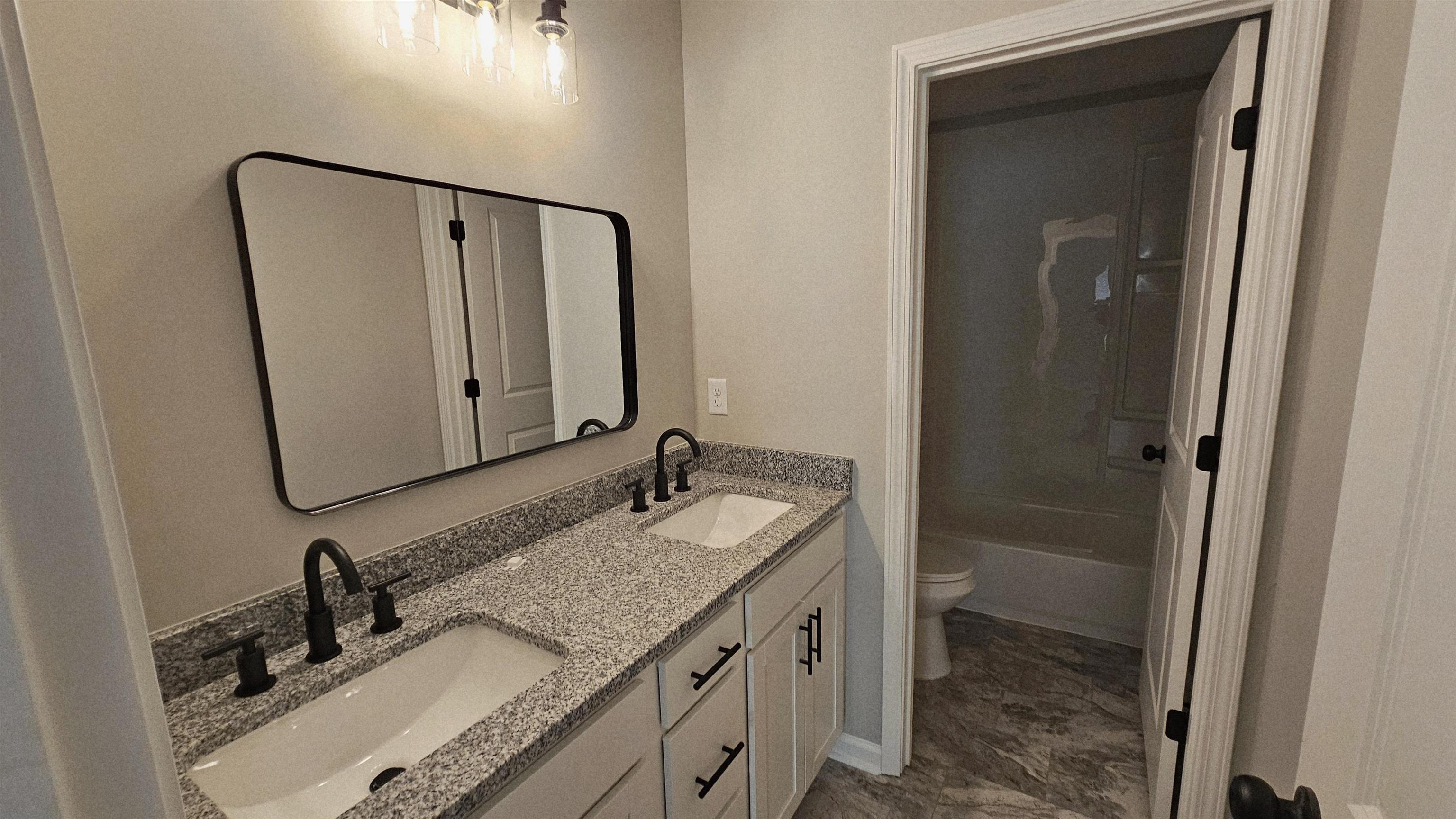 2234 East Alcy Road Memphis, TN 38114 - Photo 19 of 23 a bathroom with a granite countertop sink and a mirror