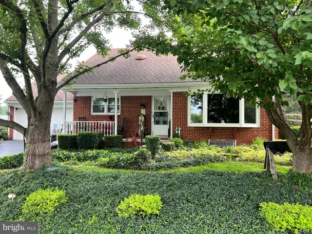 a front view of a house with a yard and potted plants