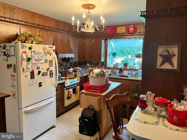 a white kitchen with a refrigerator and a stove