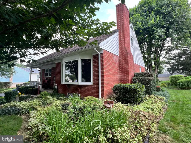 a view of a house with a yard and potted plants