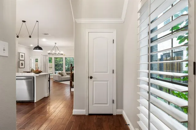 a kitchen with white cabinets and wooden floor
