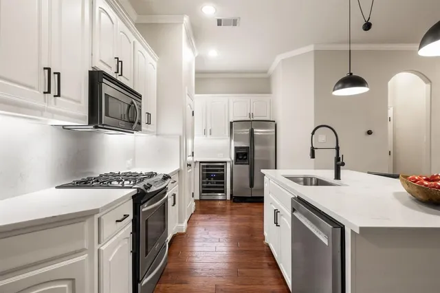 a kitchen with a sink a stove and chairs