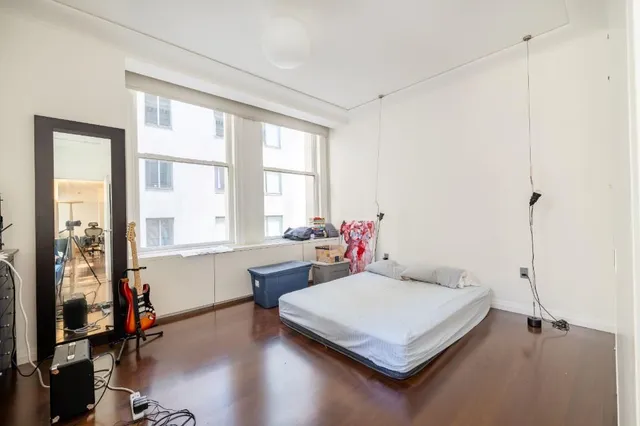 a bedroom with a bed and wooden floor