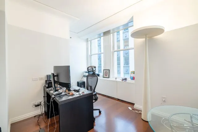 a view of a workspace with furniture and a window