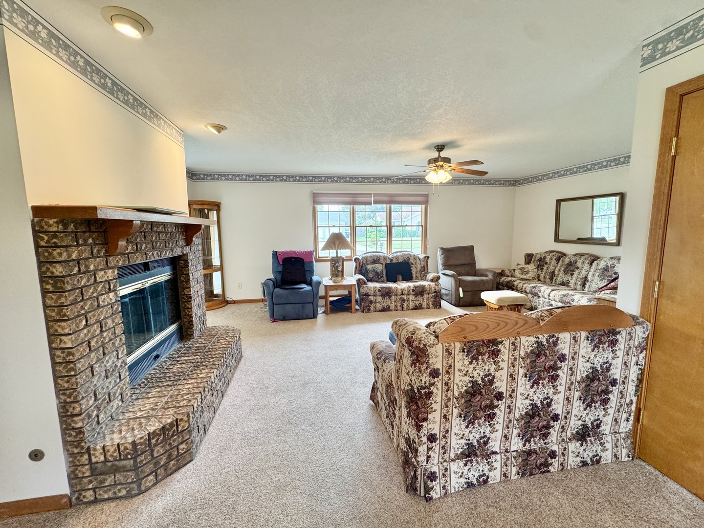 31 Colonial Drive Clinton, IL 61727 - Photo 7 of 24 a living room with furniture a fireplace and a large window