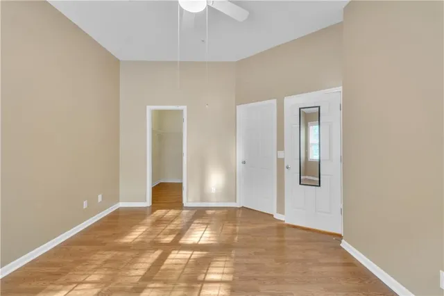 a view of a room with wooden floor and a ceiling fan