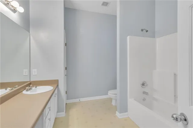 a bathroom with a granite countertop sink a toilet and bathtub
