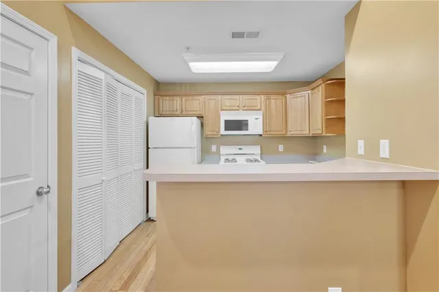 a kitchen with stainless steel appliances granite countertop a sink a stove a refrigerator with white cabinets and a refrigerator