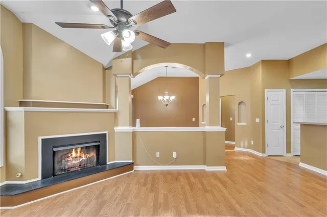 a view of an empty room with a fireplace and fan