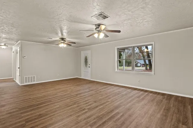 a view of an empty room with wooden floor