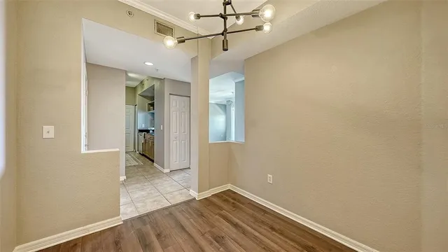 a view of a hallway with wooden floor and a bathroom