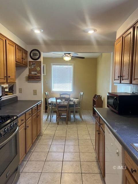 103 North Clay Street Independence, CA 93526 - Photo 6 of 25 a kitchen with stainless steel appliances granite countertop a stove a sink and a microwave