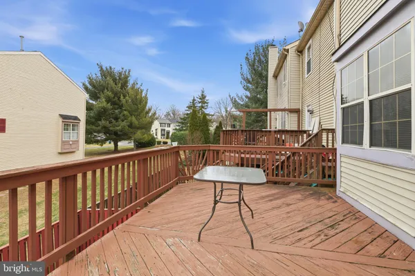 a balcony with wooden floor table and chairs