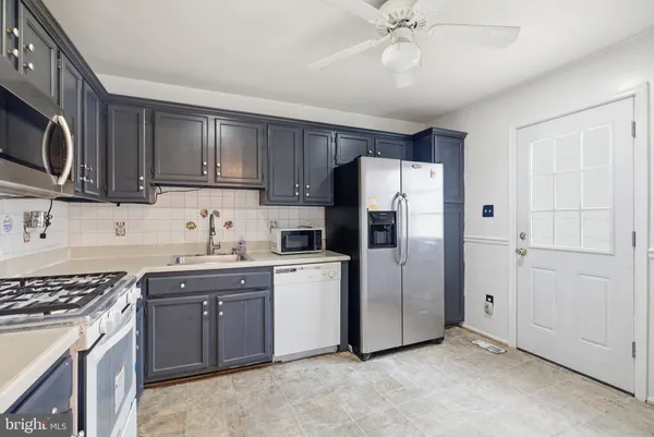 a kitchen with stainless steel appliances granite countertop a refrigerator stove a sink dishwasher and microwave with cabinets