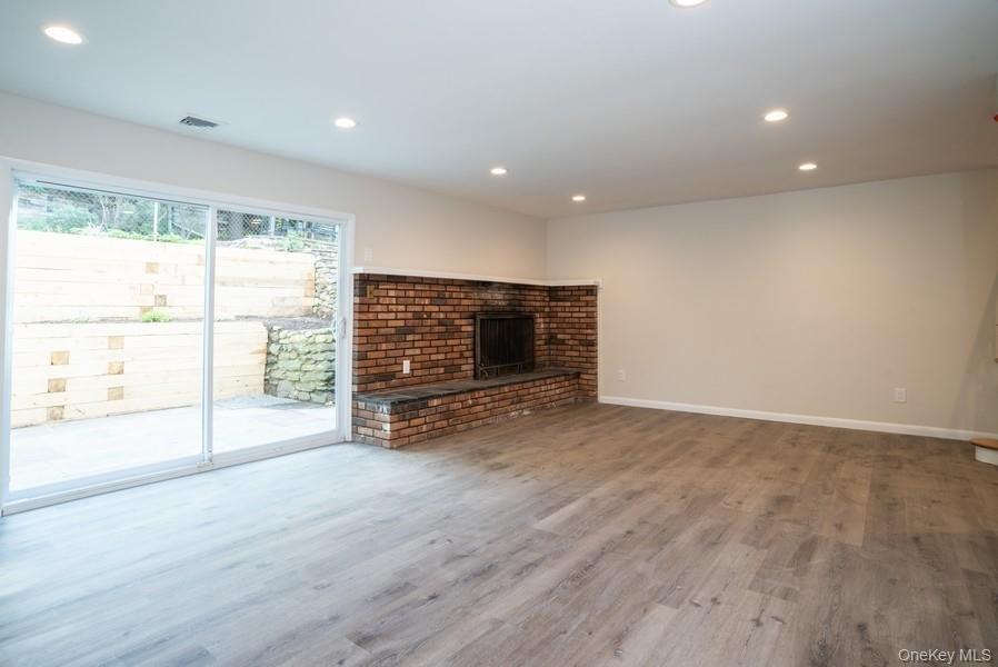 17 Vista Drive Great Neck, NY 11021 - Photo 16 of 20 Unfurnished living room featuring recessed lighting, wood finished floors, and a brick fireplace