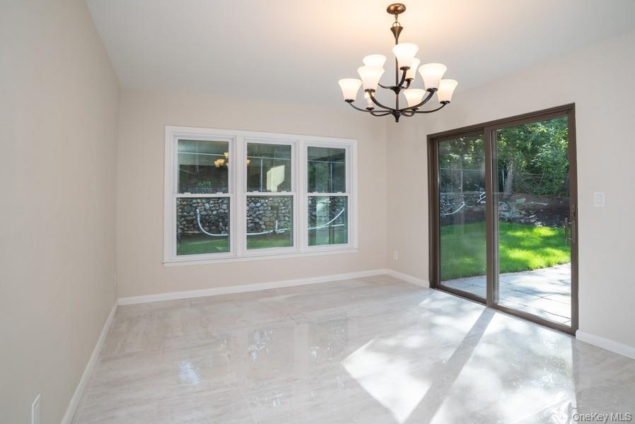 17 Vista Drive Great Neck, NY 11021 - Photo 8 of 20 Empty room featuring a chandelier and baseboards