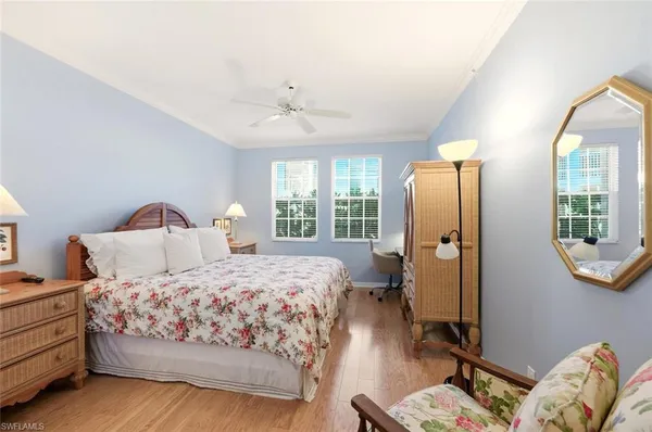 a bedroom with a bed a mirror and a window