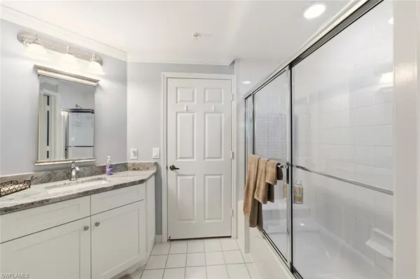 a bathroom with a double vanity sink mirror and shower