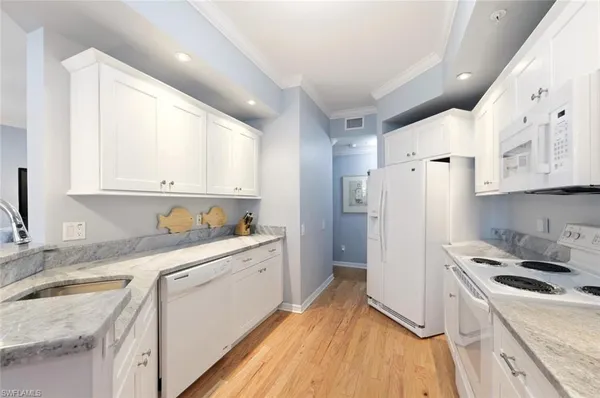 a kitchen with a sink a refrigerator a microwave and cabinets