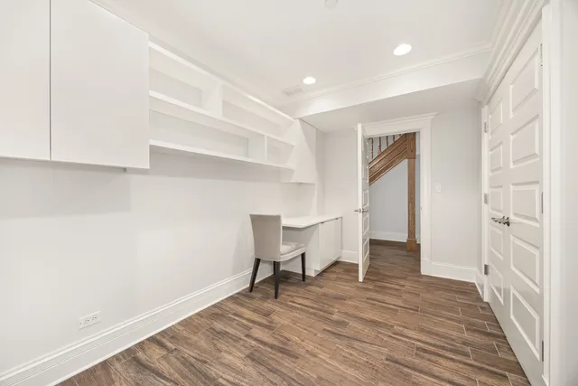 a view of a room with wooden floor and furniture