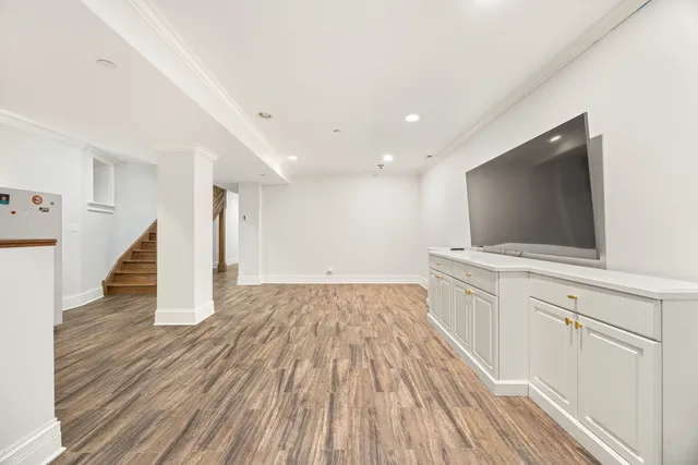a view of a livingroom with wooden floor and staircase