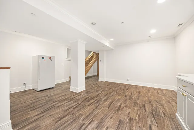 a view of an empty room with wooden floor and closet