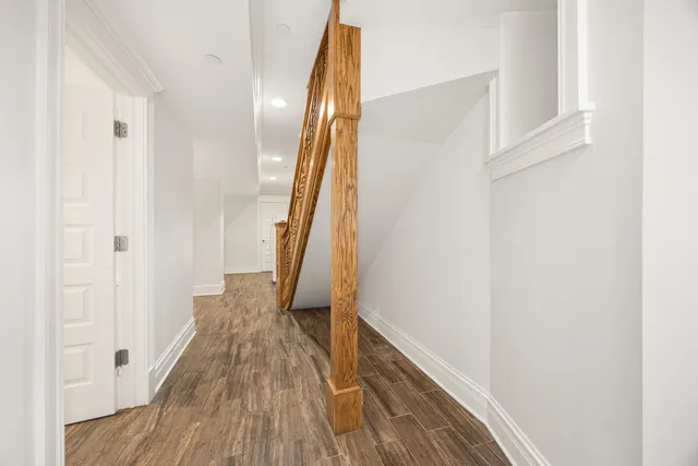 a view of a hallway with wooden floor and staircase