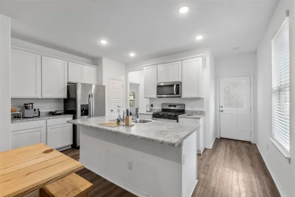 a kitchen with a sink a counter top space stainless steel appliances and cabinets