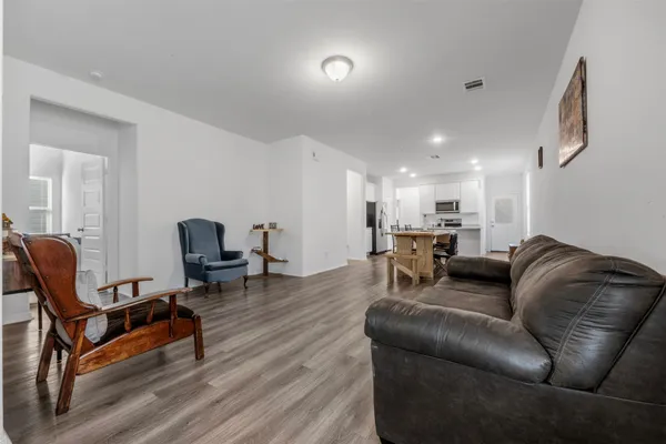 a living room with furniture and a wooden floor