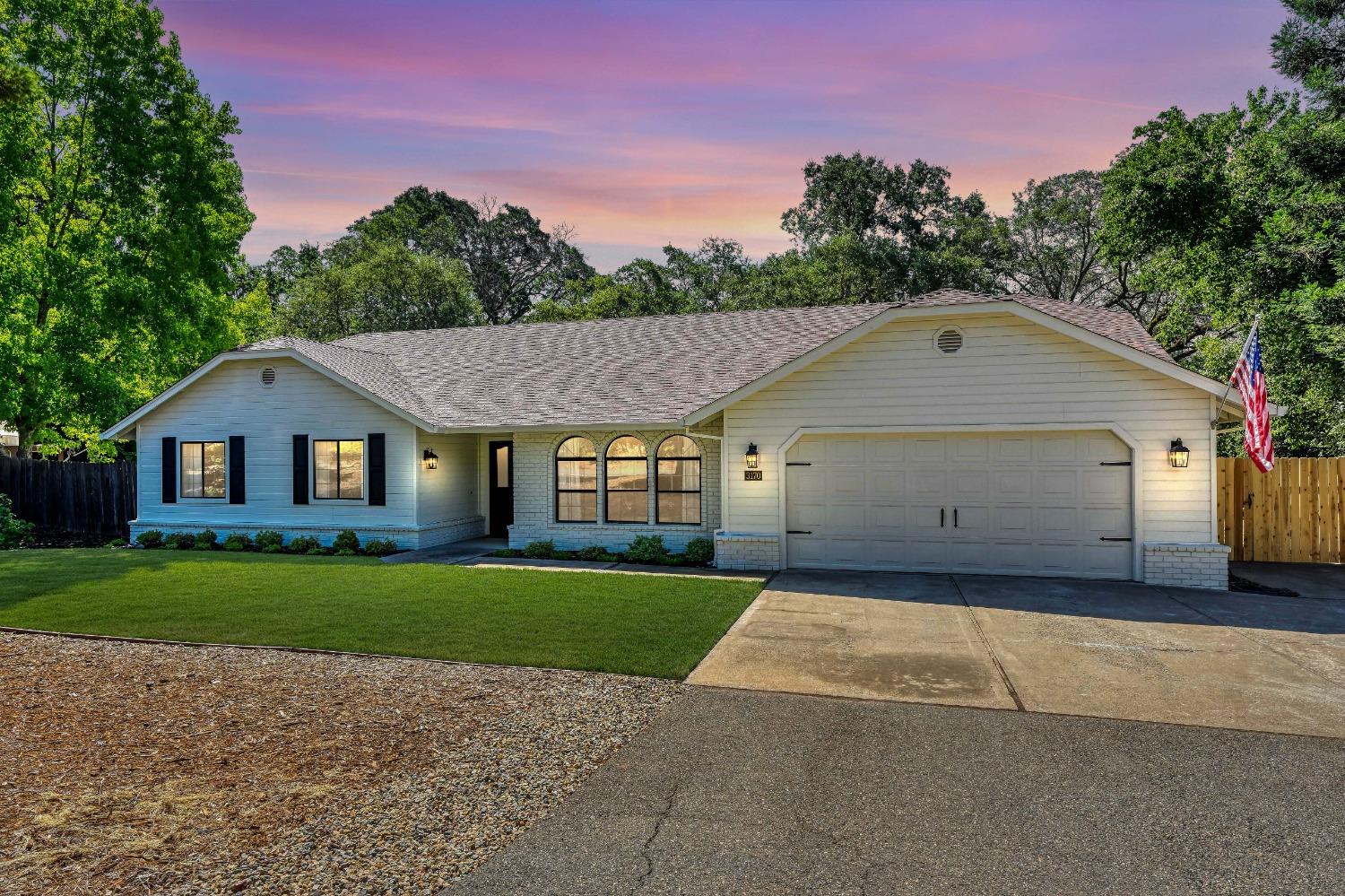 a view of a big house with a big yard and large trees