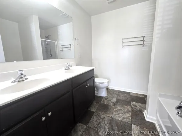 a bathroom with a double vanity sink a mirror and a toilet