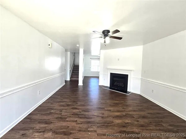 a view of a hallway with wooden floor and a fireplace