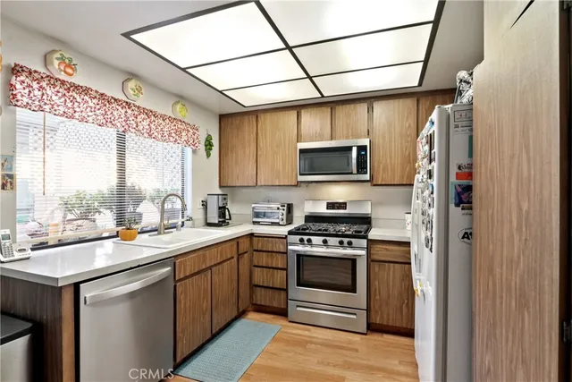 a kitchen with a sink appliances cabinets and a counter top space