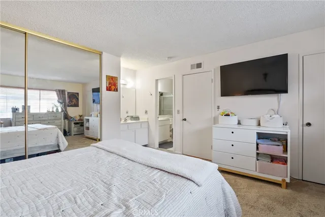 a bedroom with a large bed and flat tv screen